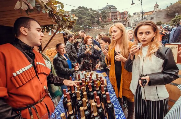 Tbilisi, Georgia - October 16, 2016: Women talking about wine with Georgian man during the Tbilisoba festival