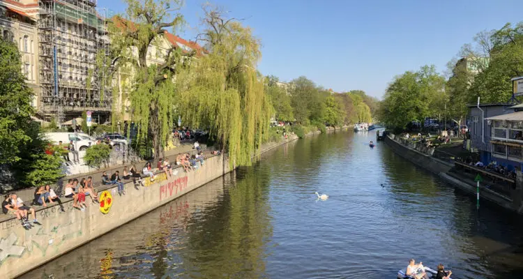 Berlin, Germany - april 2019: People enjoying sunny weather on the street, sitting at riverside in Berlin, Kreuzberg during spring