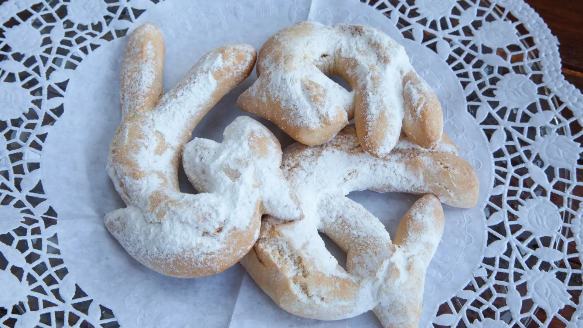 Three Cucarin cookies topped with icing sugar.