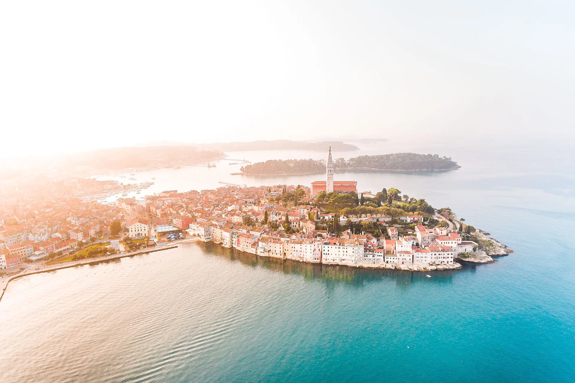 This is a panoramic drone shot of Rovinj at sunset.