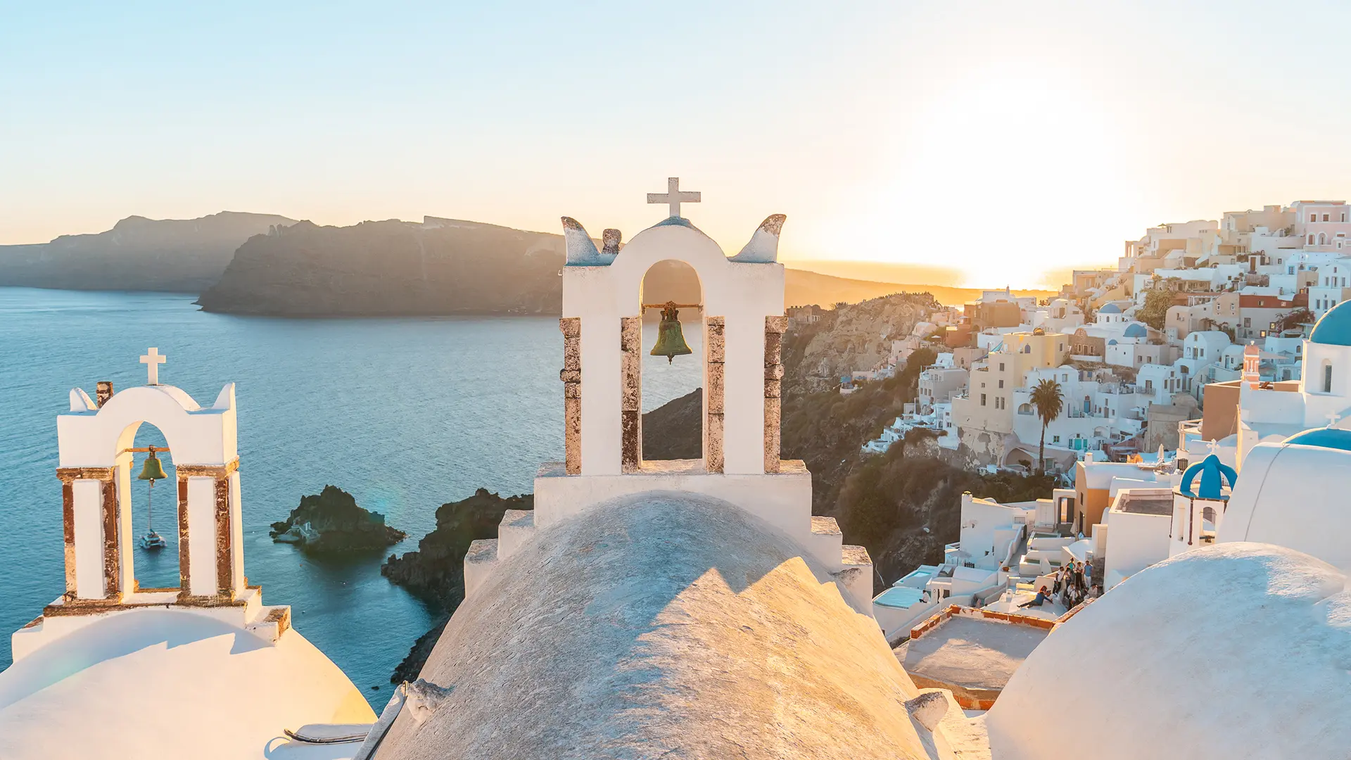 This image shows the view of Fira in the background and a traditional Greek bell tower in the foreground.