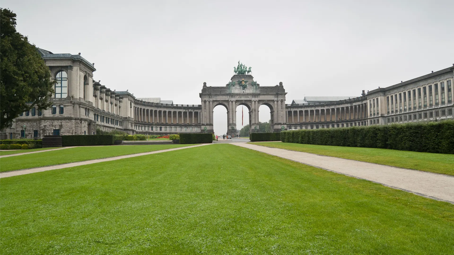 This image shows a magnificent arch in the background and a green space in the foreground.