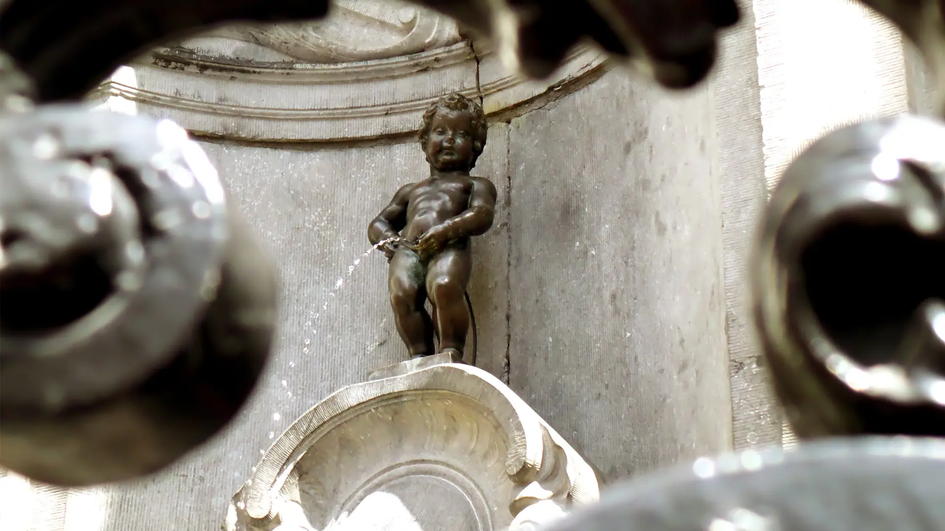 This image shows Manneken Pis, the bronze statue of a little boy.
