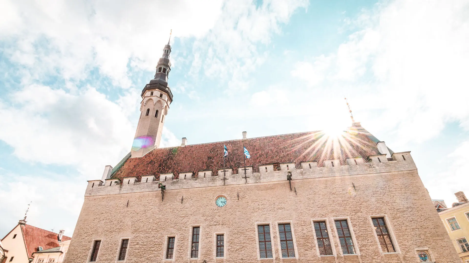This is a close-up of a red-tiled roof building under a bright sky.