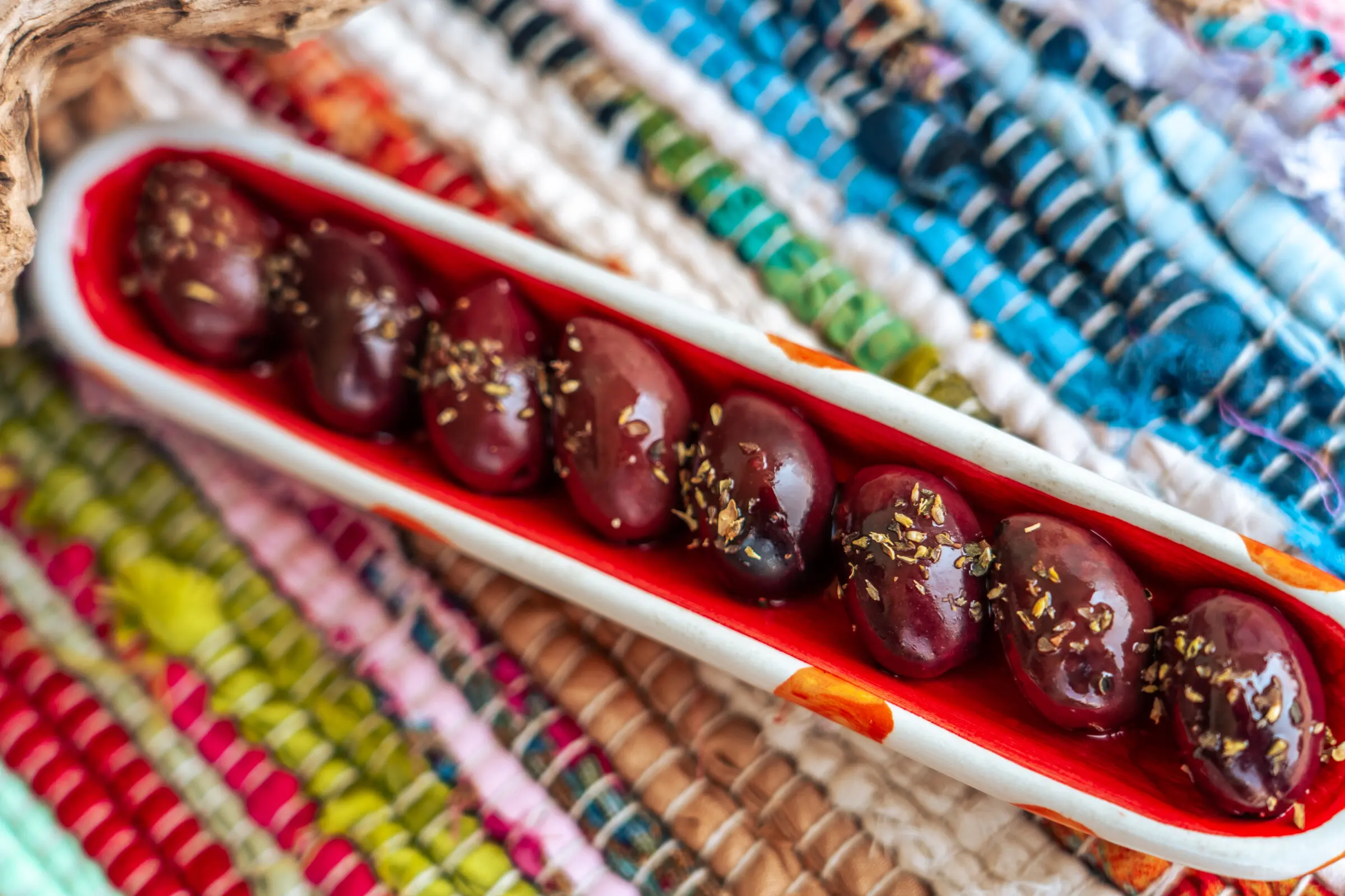 This is a close up of big brown Kalamata Olives topped with oregano.