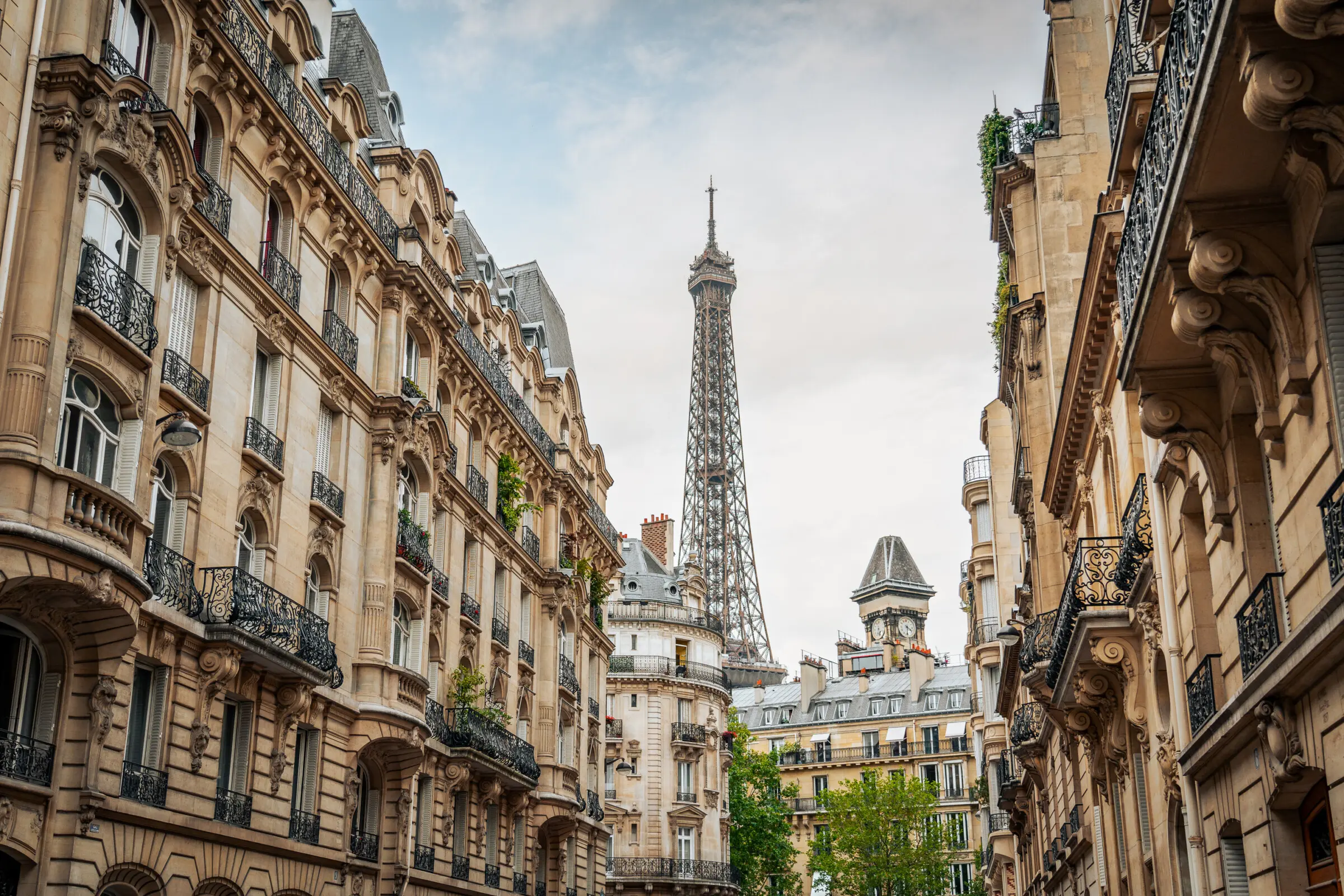 This image shows the top part of the Eiffel Tower in the background with some typically Parisian buildings in the foreground.