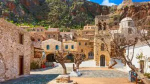 This image shows the main square inside the castle town of Monemvasia. There are medieval houses and a bell tower.