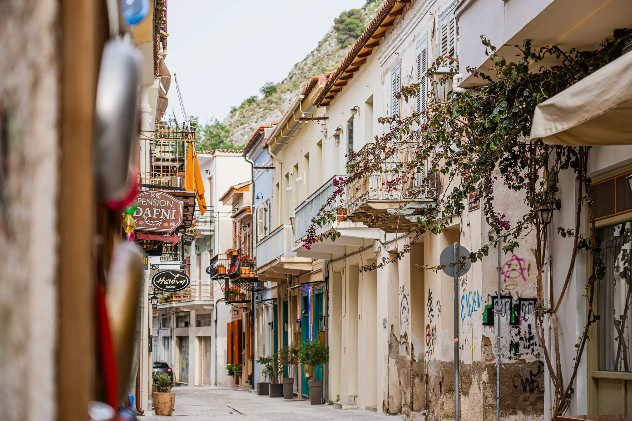 This is a photo of the neoclassical mansions that line a street in the Old Town of Nafplio, one of the best places to stay we recommend in this Peloponnese travel guide.