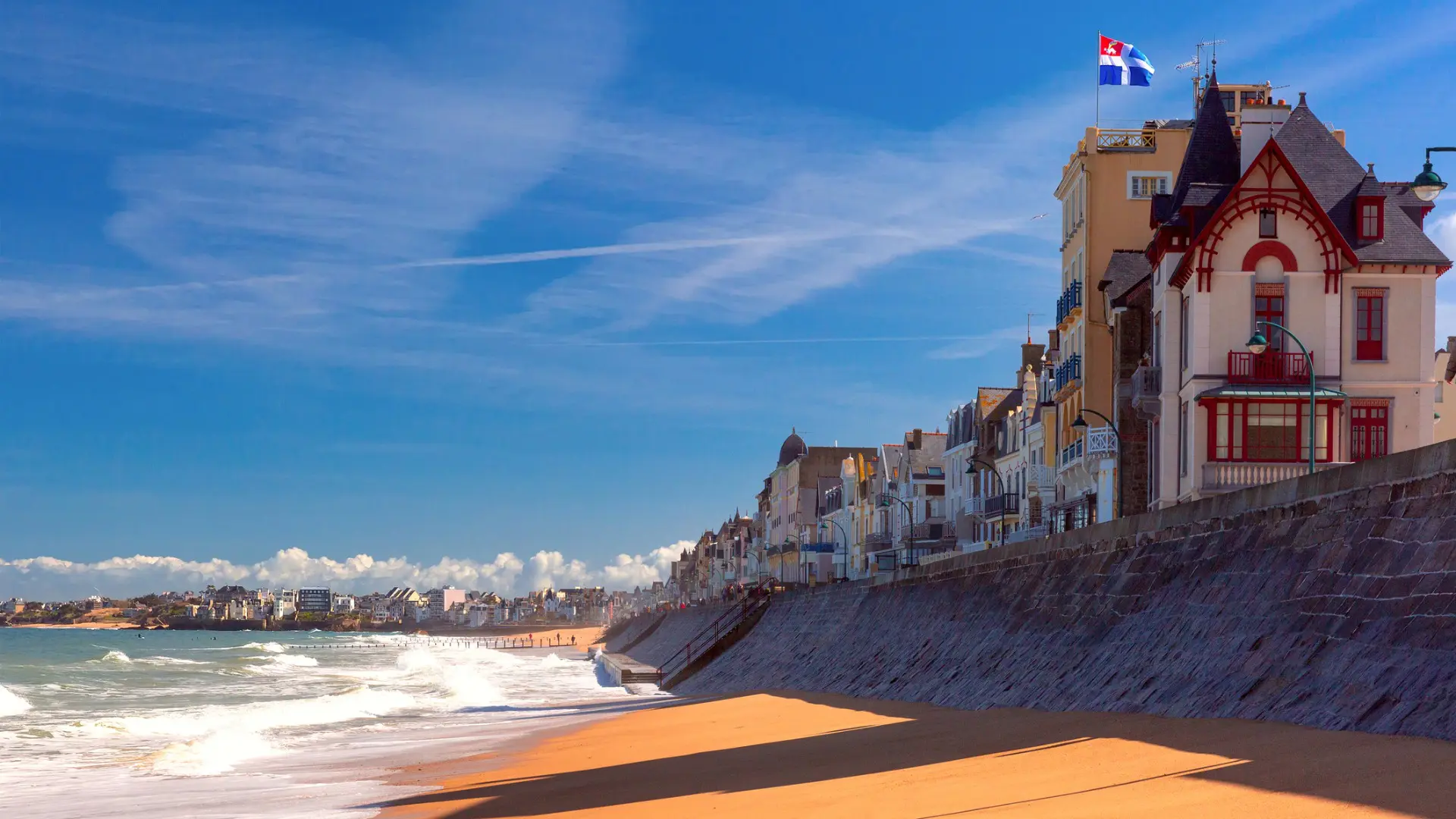 This image shows a line of picturesque buildings built along a golden sand beach in Saint-Malo, one of the most beautiful places to visit in France.