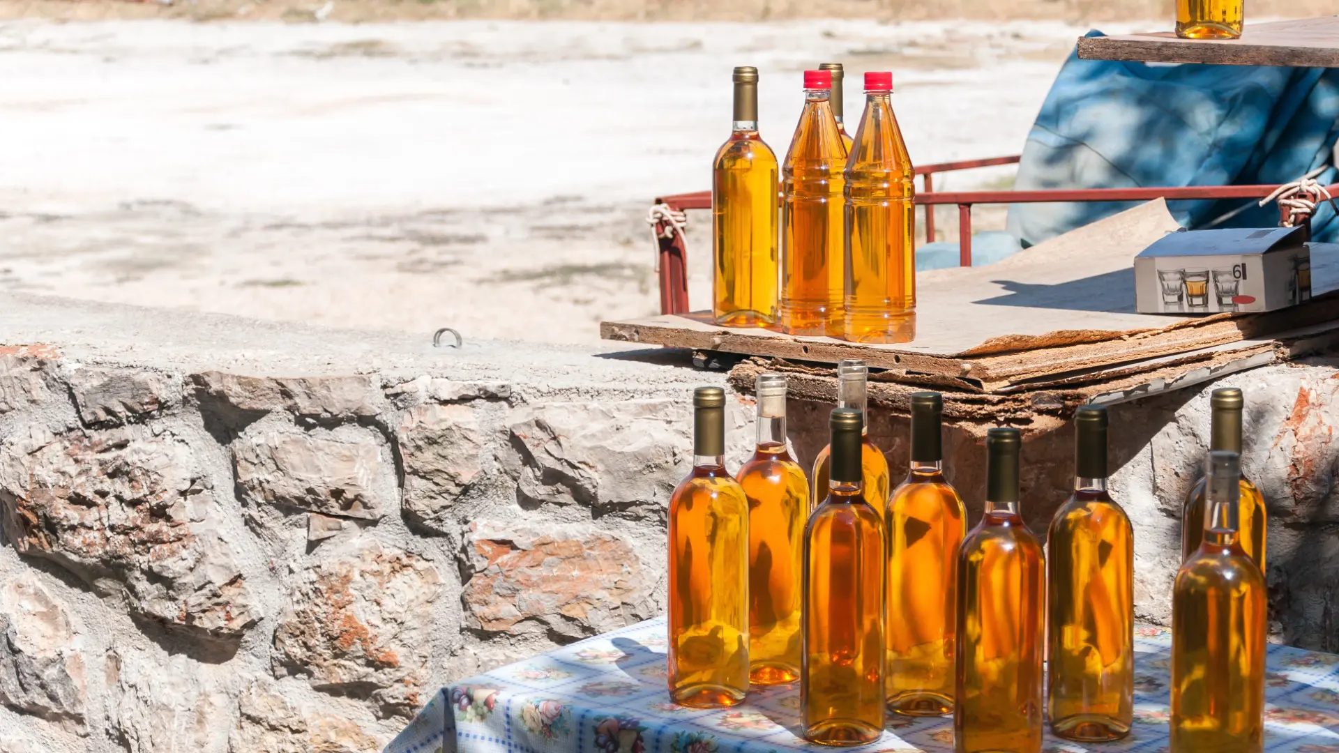 Several plastic and glass bottles of amber-colored Prosek.