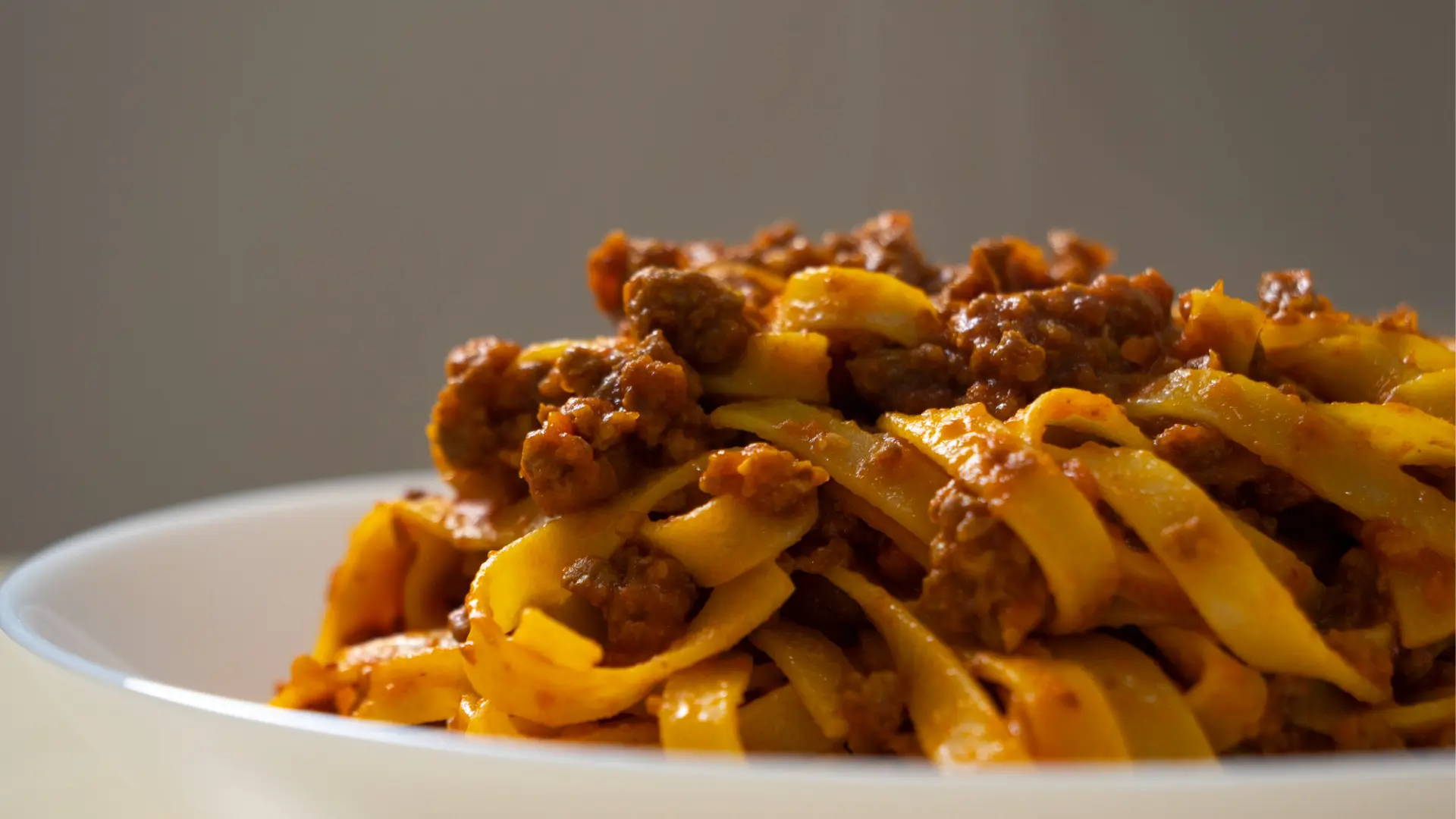 A close up of a dish filled with tagliatelle al ragu, a staple of Italian cuisine.
