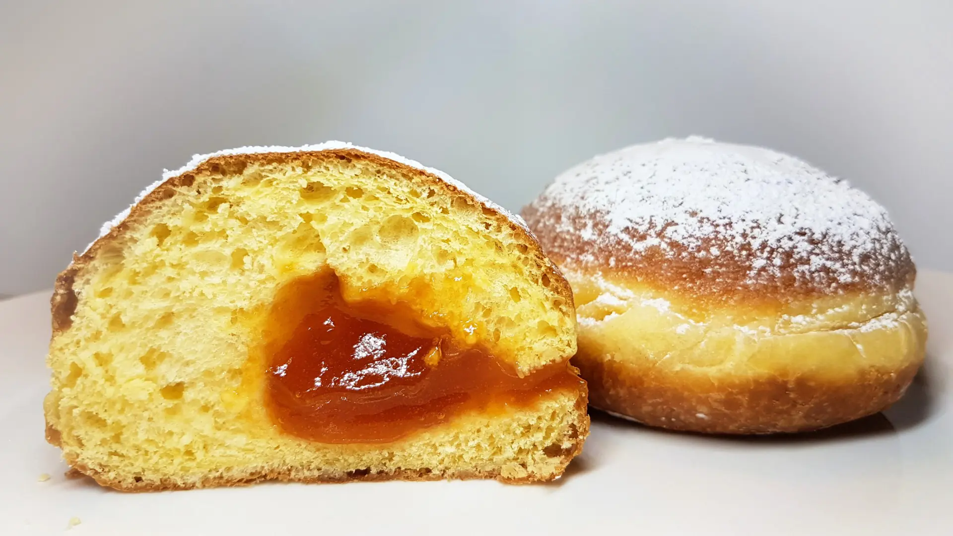 A close-up of one and a half Viennese doughnuts filled with apricot jam, among the best desserts in Vienna.