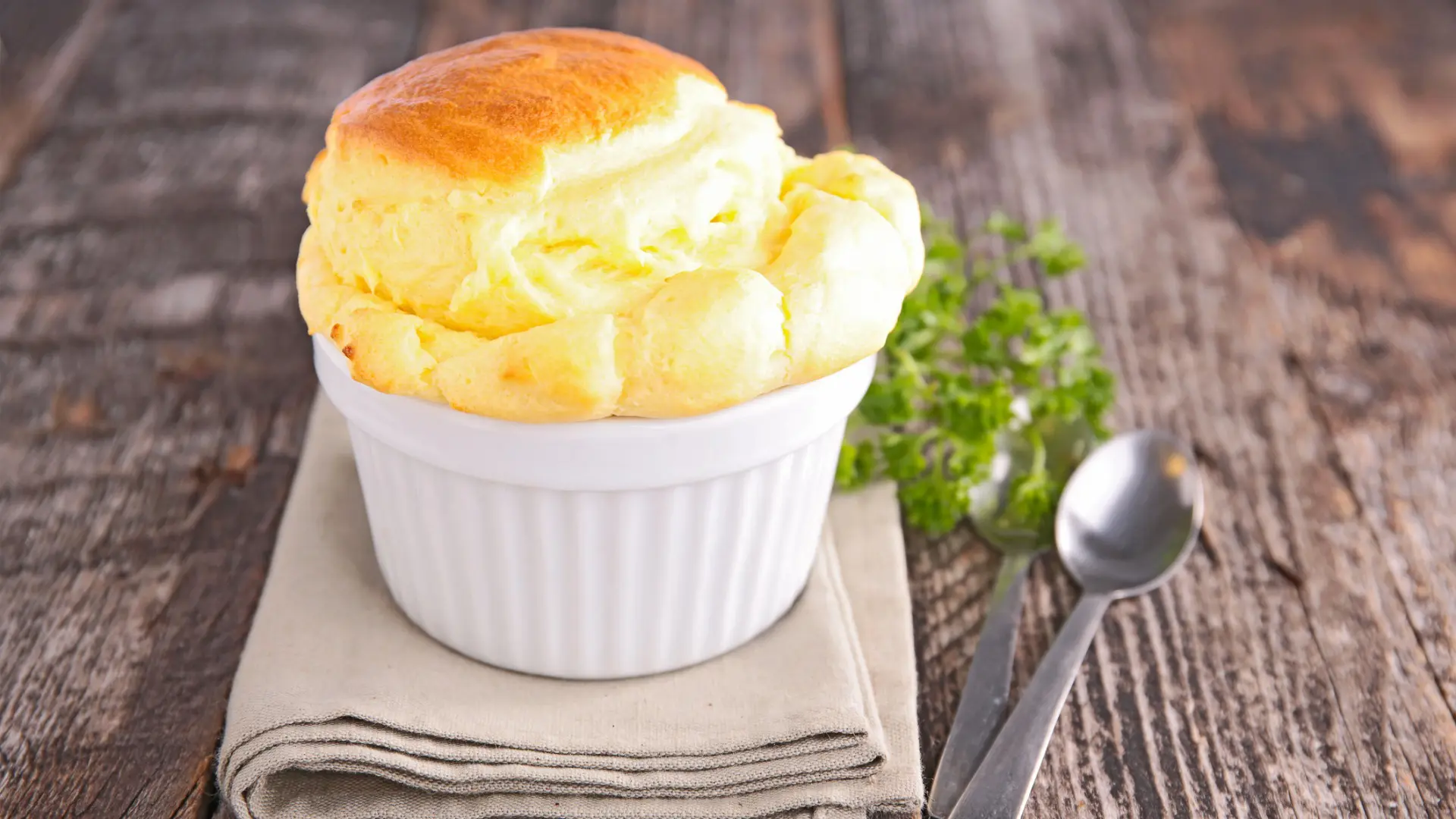 A close up of a puffy French cheese souffle, a staple of the best French food.