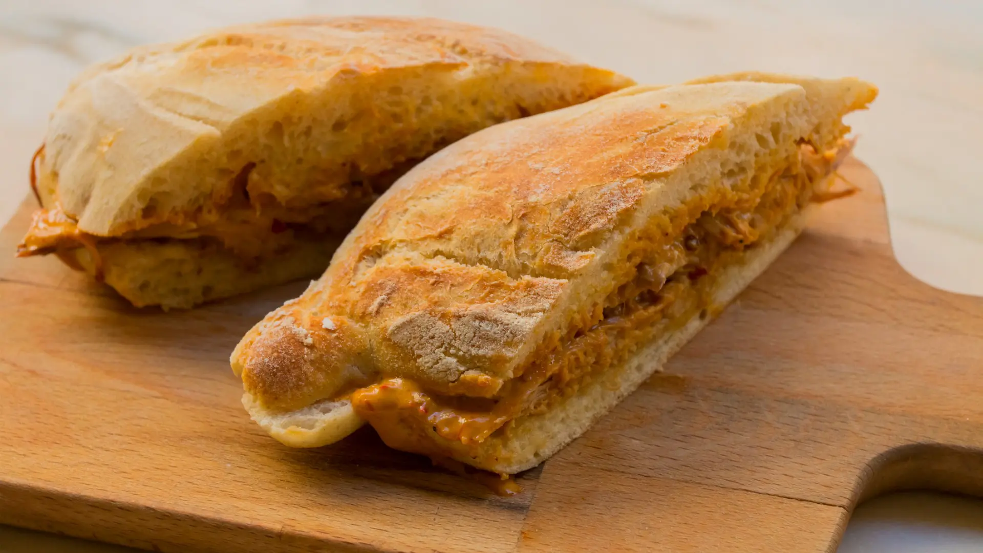 A close up of two pieces of bread filled with meat.