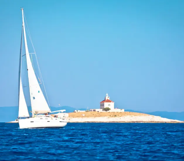 A sailboat in front of a tiny island