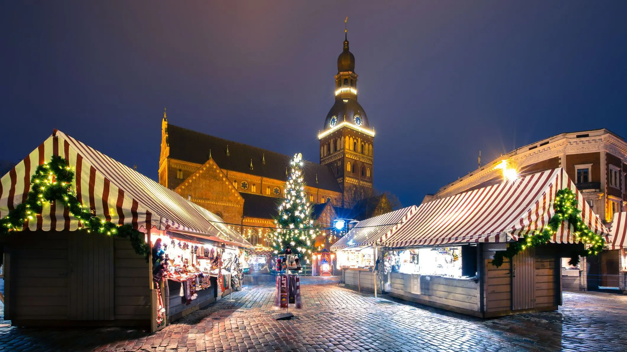 An evening shot of a decorated and illuminated Christmas tree, a Christmas Market and the Cathedral of Saint Mary on Cathedral Square in Riga.