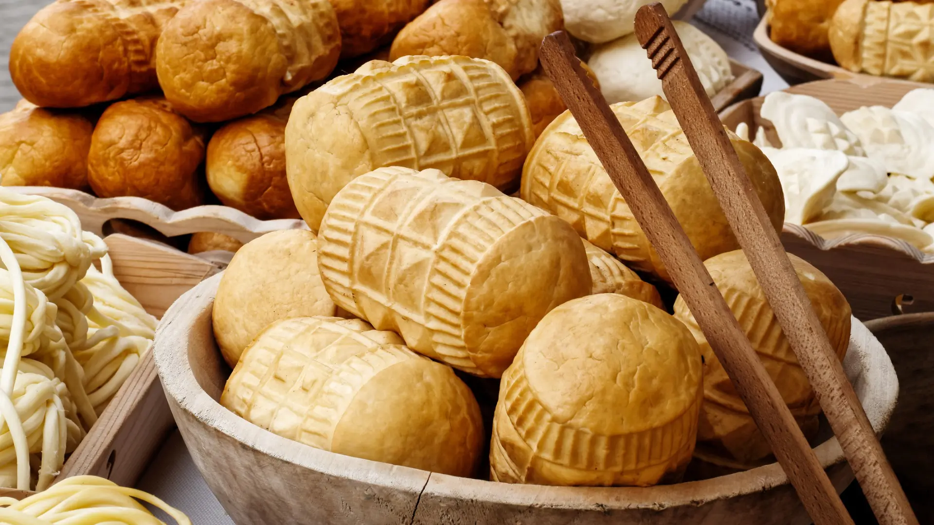 Several types of Oscypek cheese at a market.