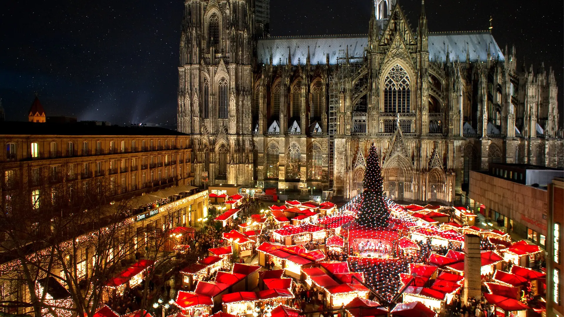 A panoramic view of Cologne's Christmas market with the imposing Cathedral in the background. For many, Christmas is the best time to visit Germany.