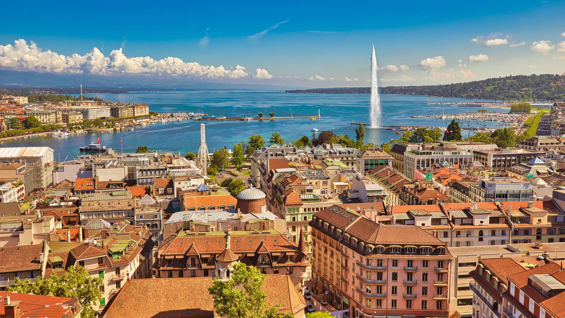 A panoramic view of Geneva with the lake and the impressive Jet d'Eau fountain in the background.