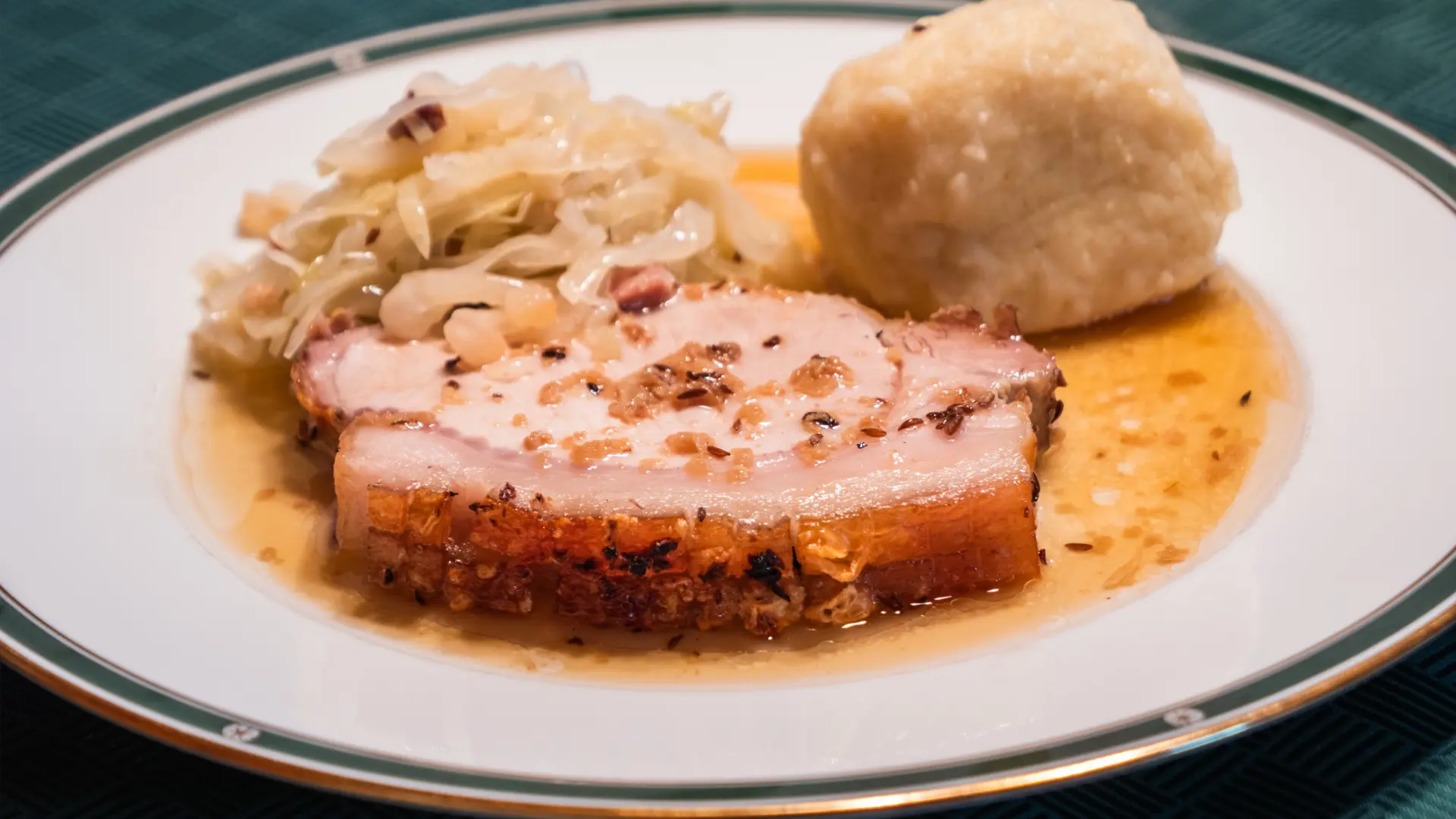 A slice of roast pork with a potato dumpling as a side.