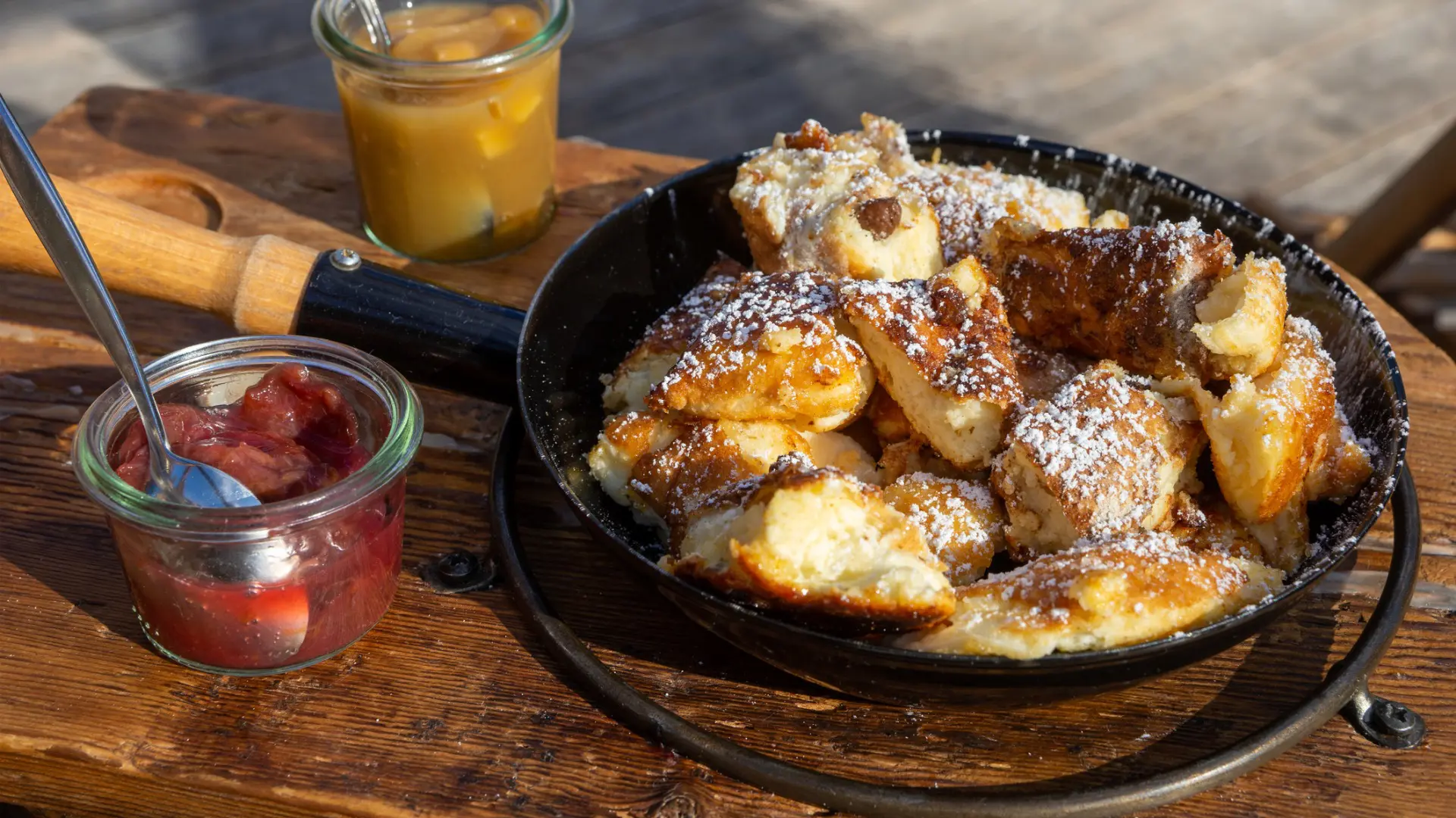 Austrian Kaiserschmarrn in a pan with apple sauce and plum jam.