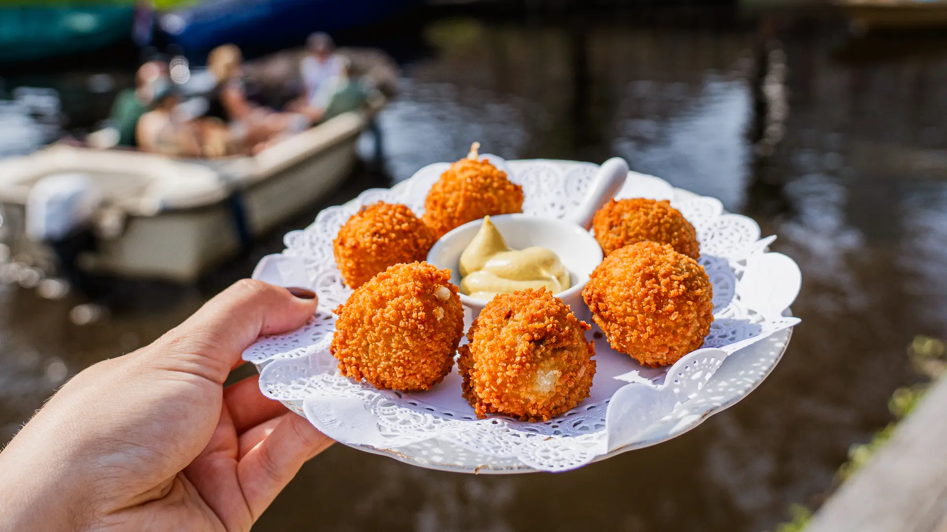 A plate of crispy deep-fried bitterballen with mustard, one of the best street foods to try in Amsterdam.