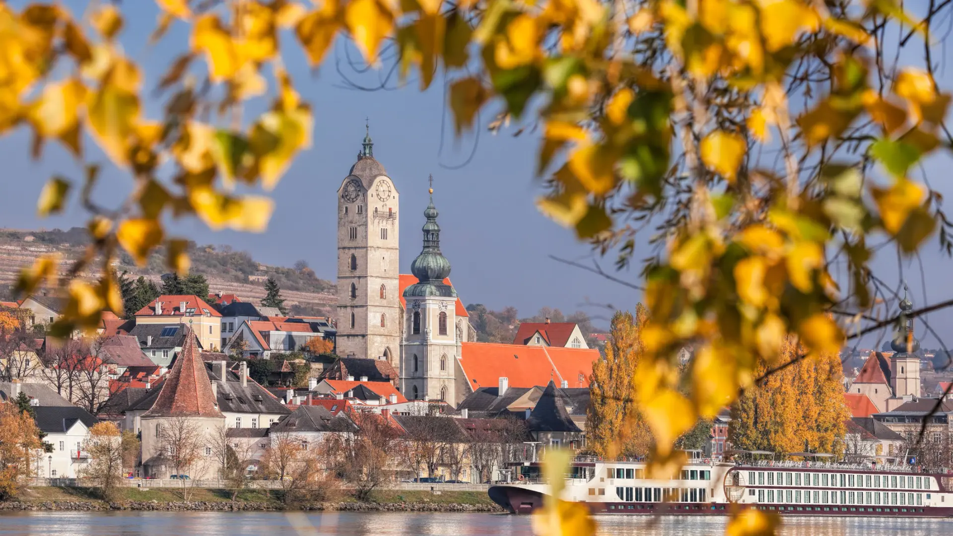 A beautiful town with autumn leaves in the foreground.