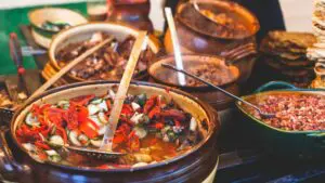 Several clay pots filled with various types of traditional Hungarian food.