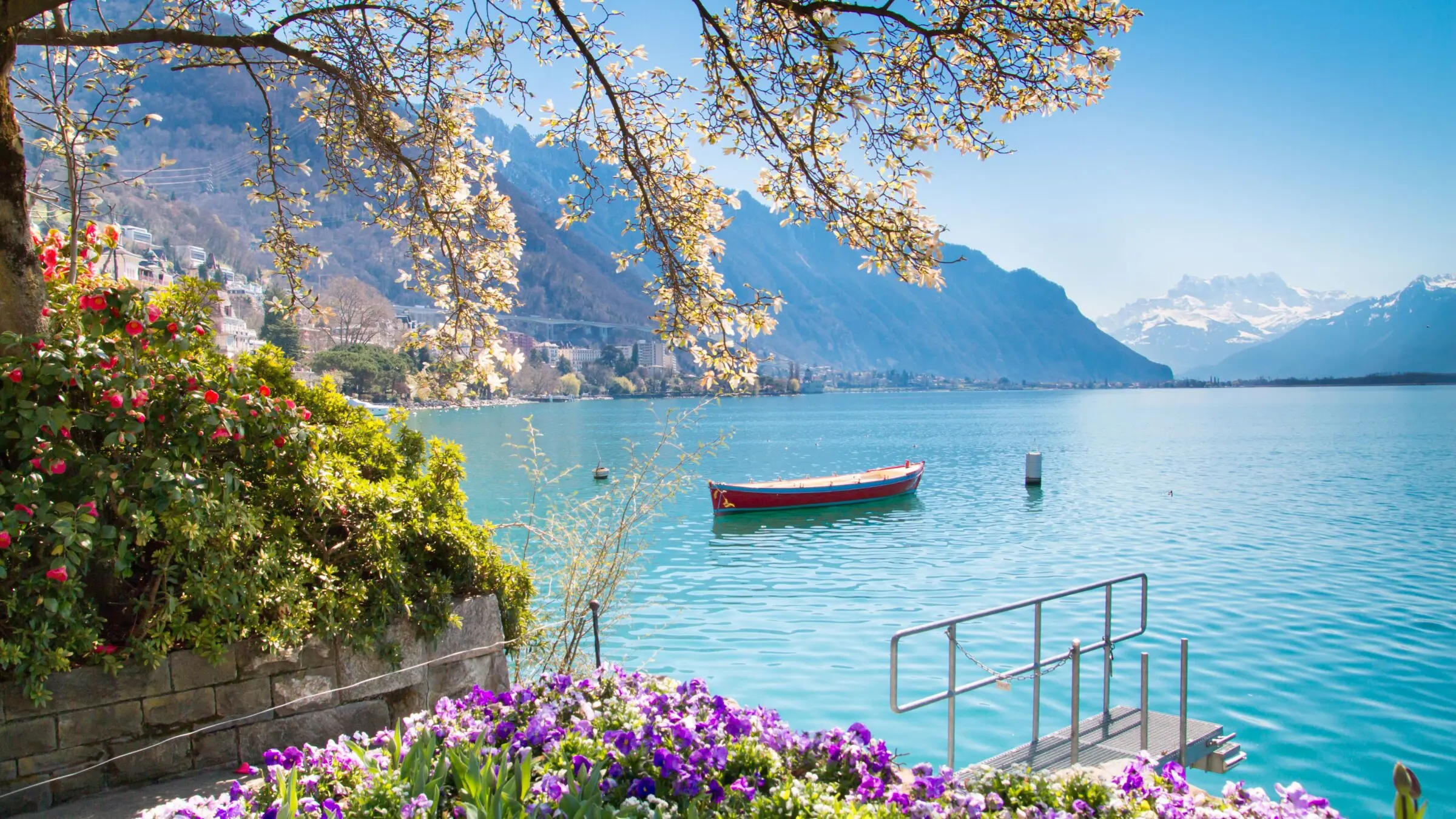A peaceful lake with a wooden boat floating near the shore.