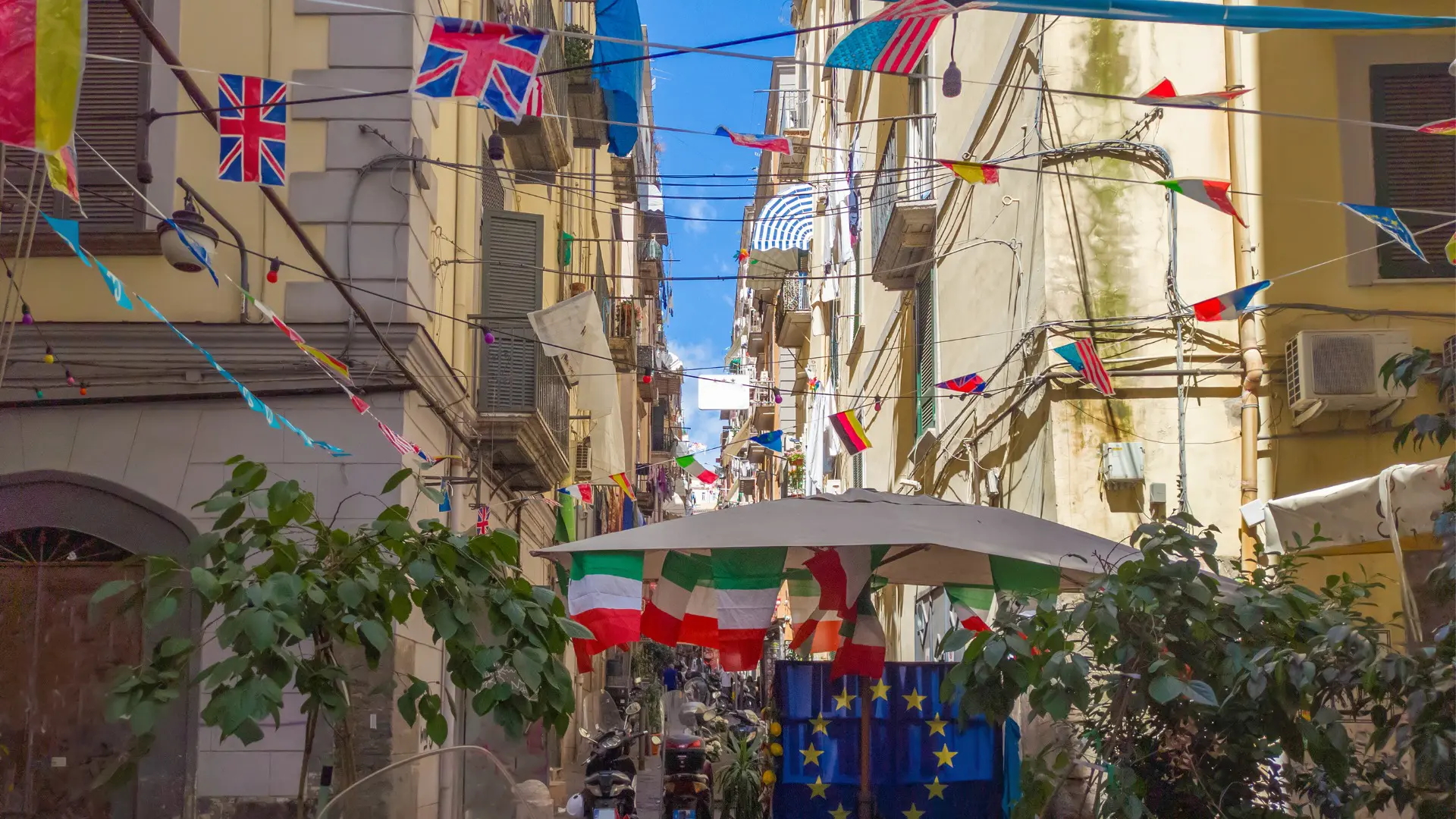 A quaint neighborhood with small flags of various countries hanging from strings.