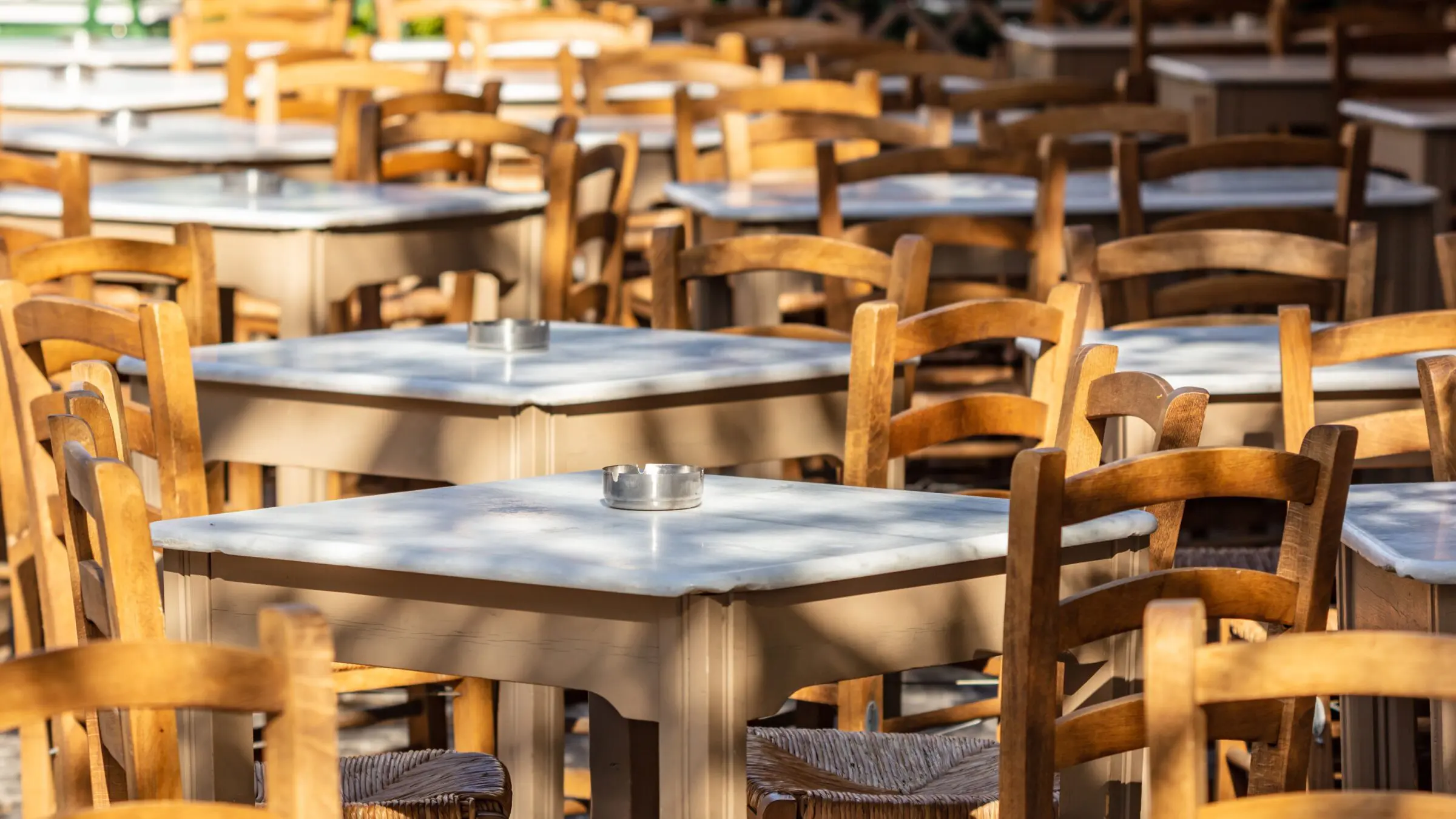 Empty tables and chairs at a traditional outdoor café in Plaka.
