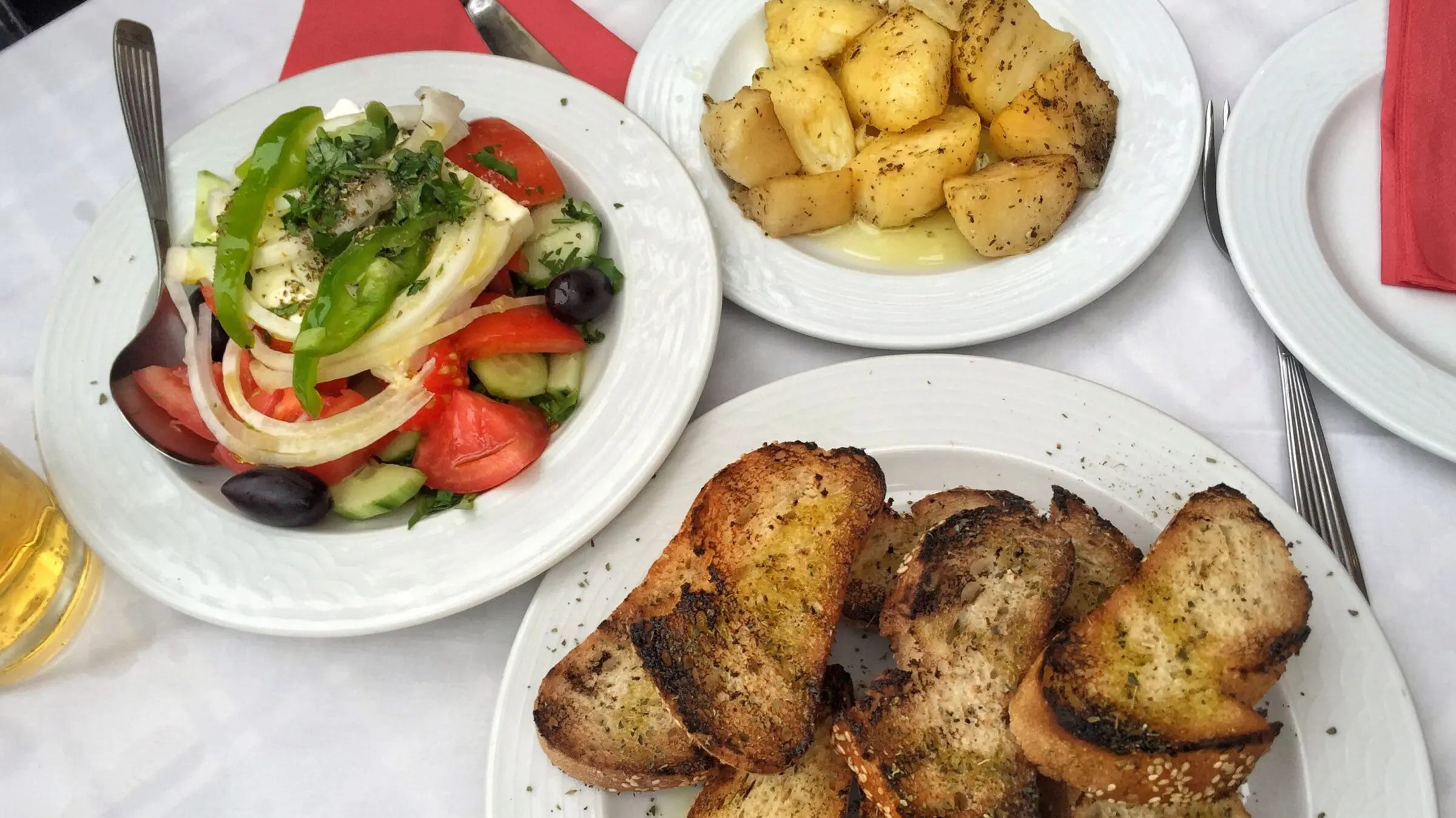 A delicious Greek salad and appetizers on a table.