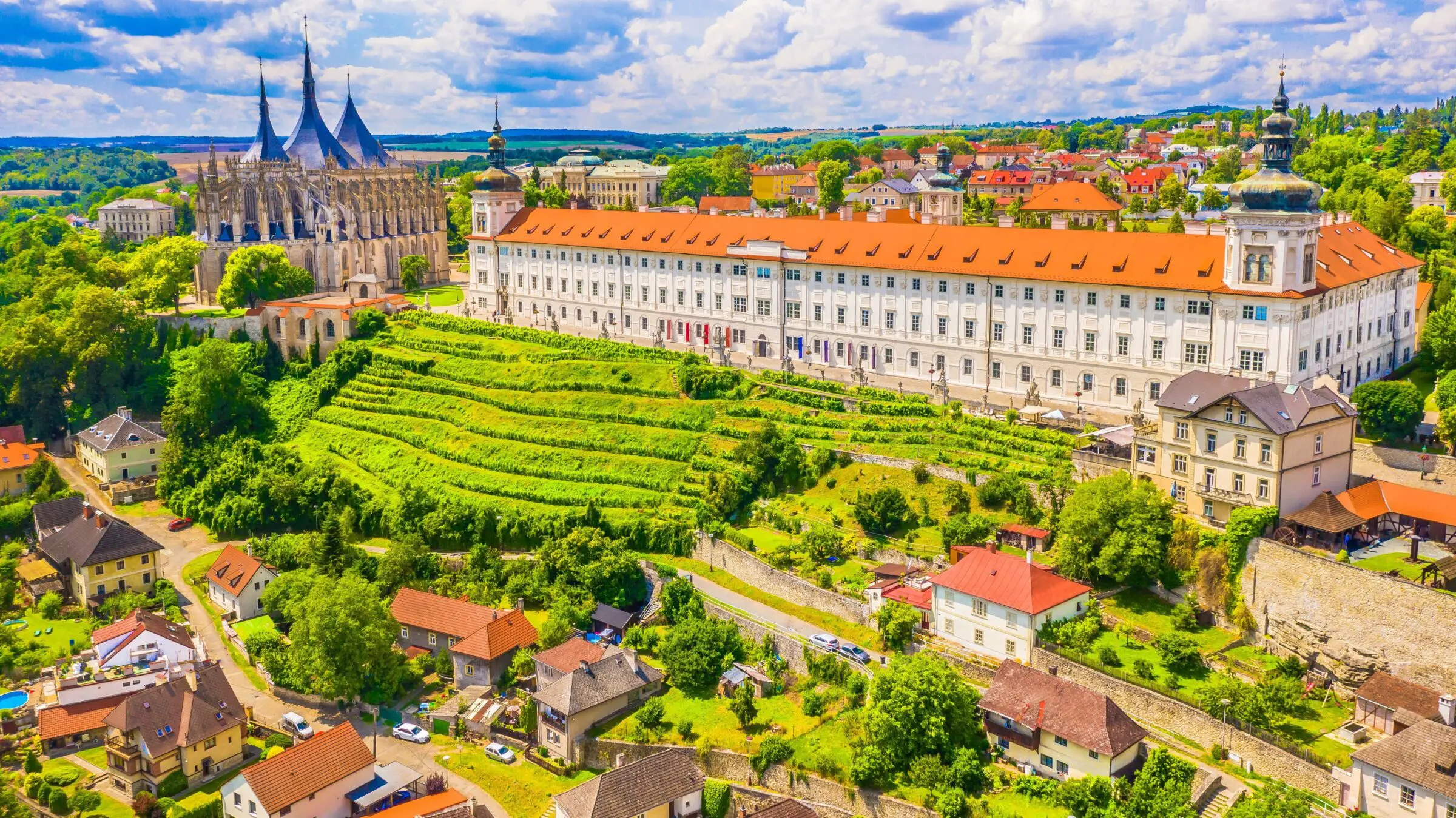 A stunning view of the historic castles and landscape of Kutna Hora, showcasing medieval architecture surrounded by lush greenery, highlighting the town’s rich architectural heritage.