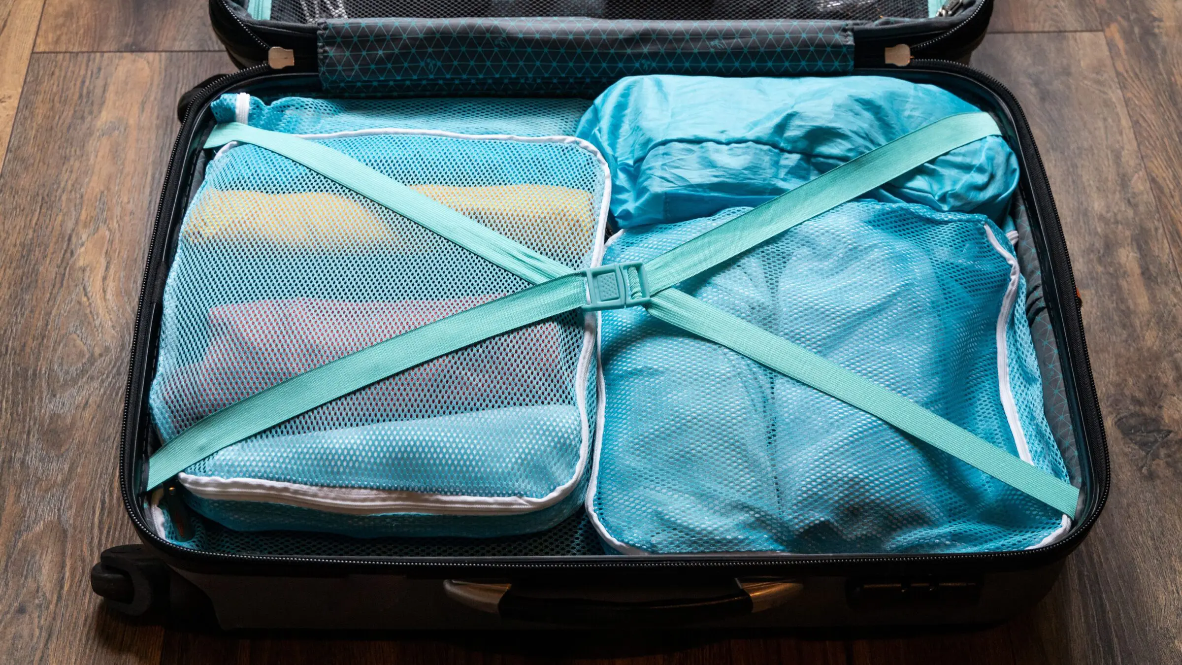 Clothes rolled and packed in packing cubes in a suitcase.
