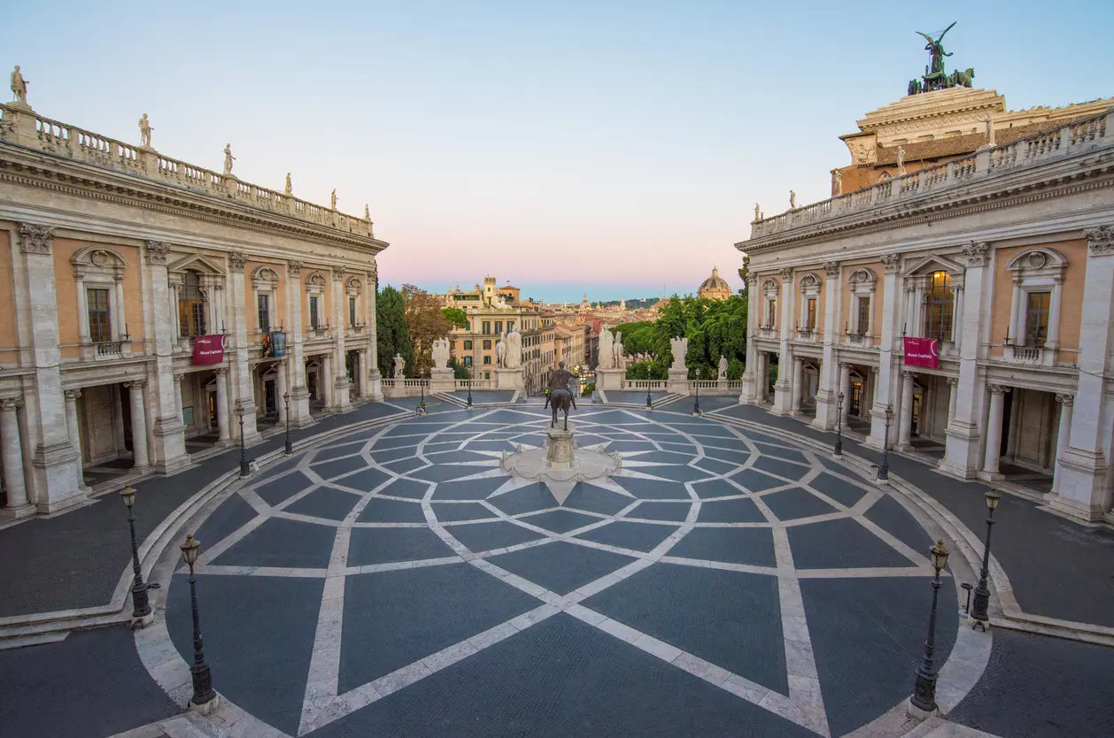 Early morning view of Piazza del Campidoglio in Rome, designed by Michelangelo, featuring the geometric pavement, statue of Marcus Aurelius, and surrounding Renaissance buildings