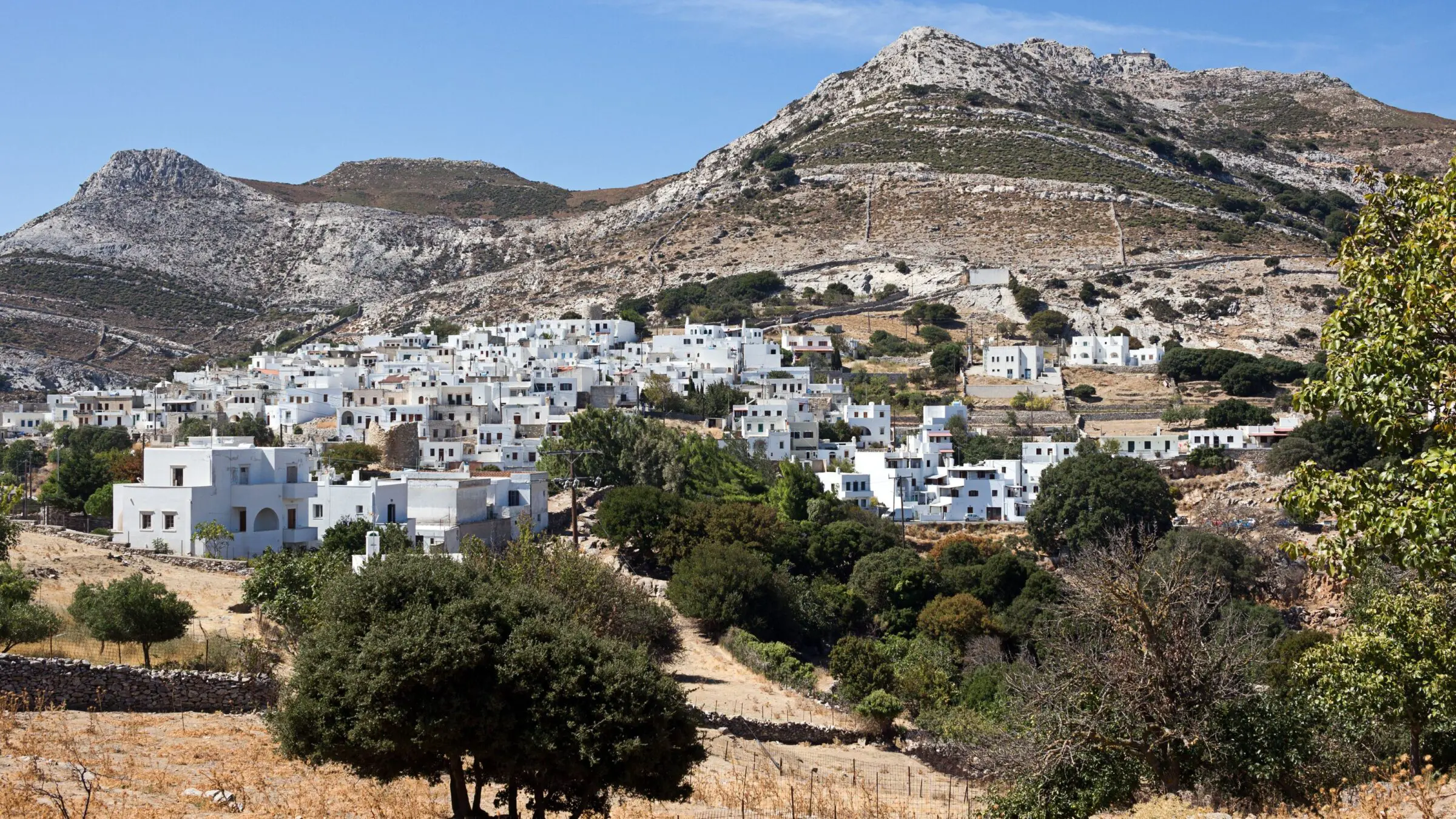 A whitewashed village built at the foot of a mountain.