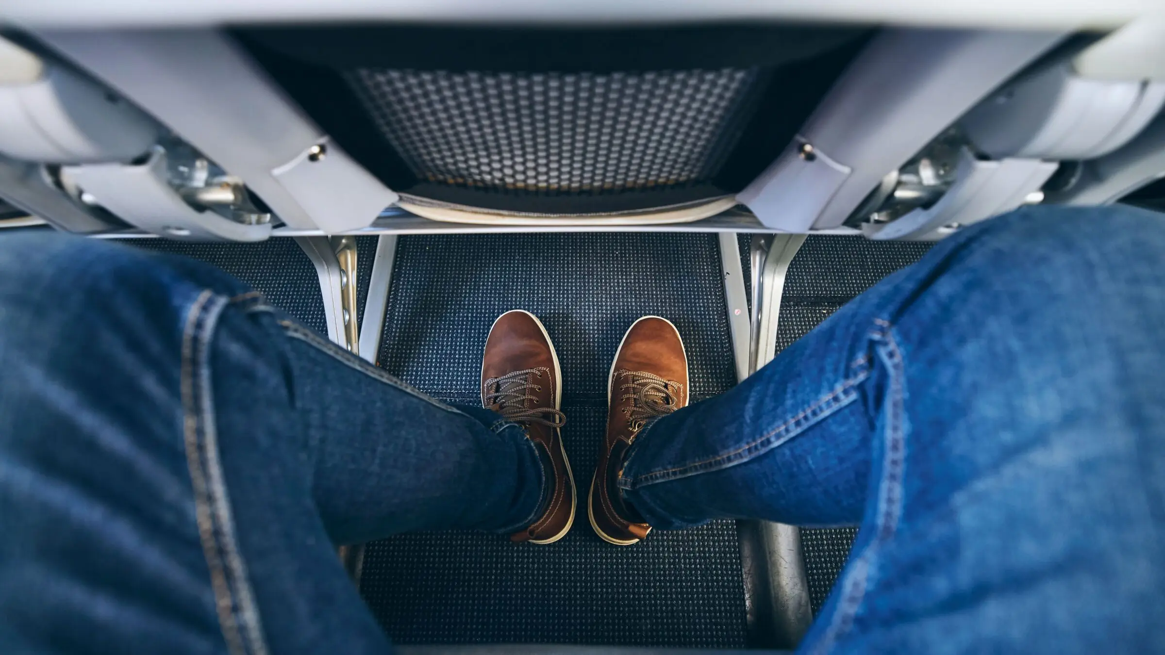 Personal perspective of a passenger's legroom on an airplane.