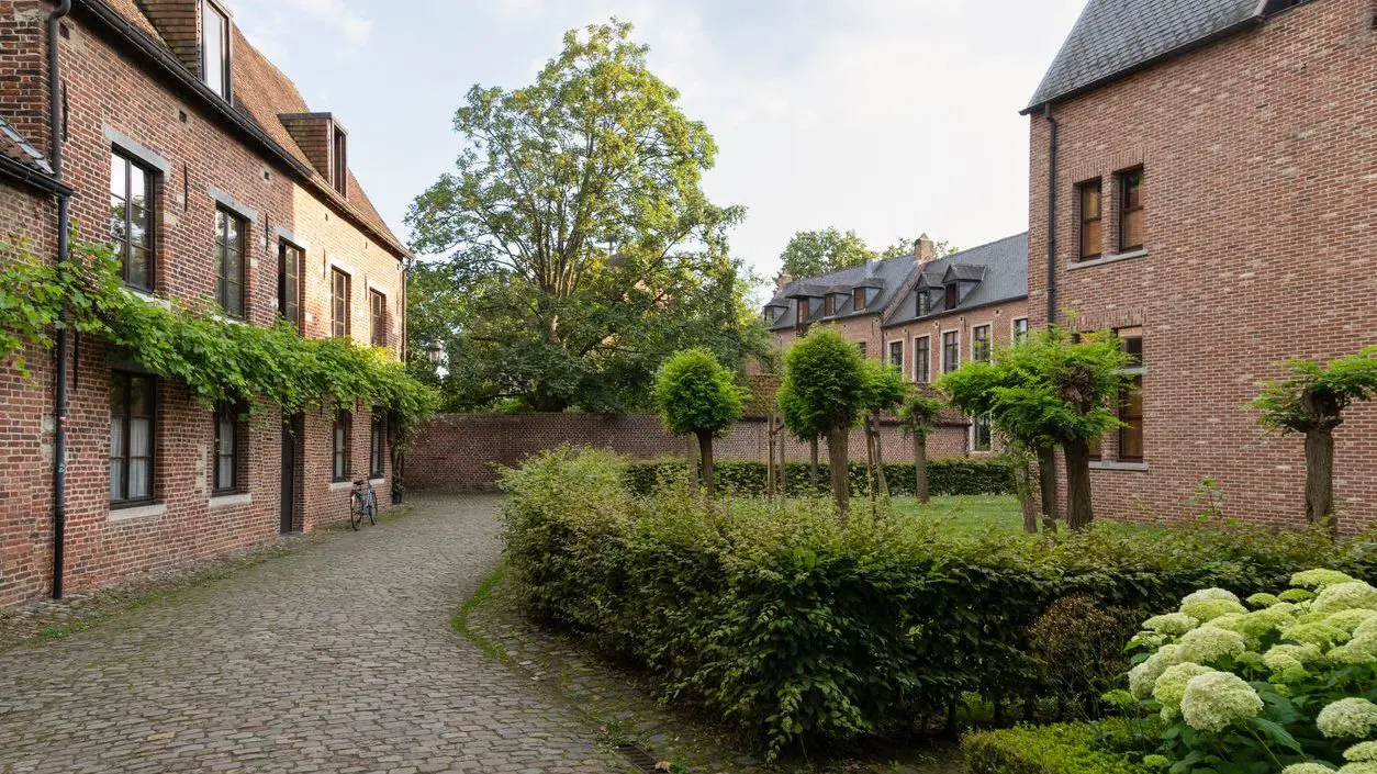 Brick-walled houses, cobbled streets and trees.