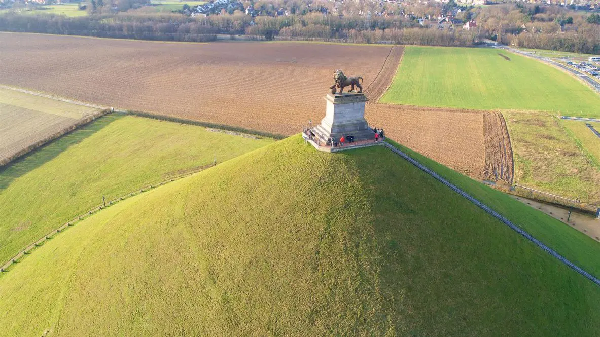 An aerial view of Lion's Mound, a green artificial hill with the statue of a lion on the top.