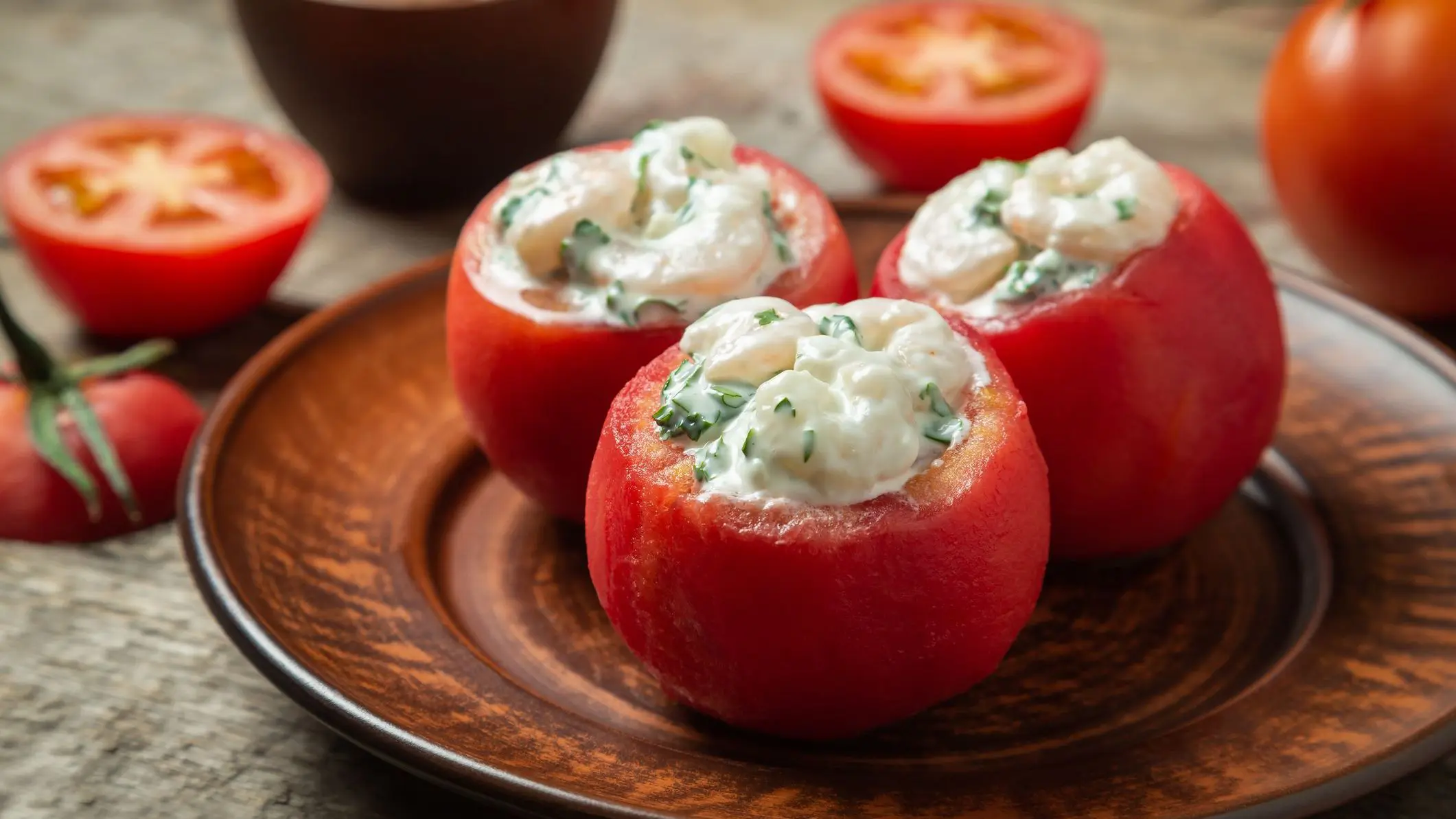 Tomatoes stuffed with shrimp served on a ceramic dish.
