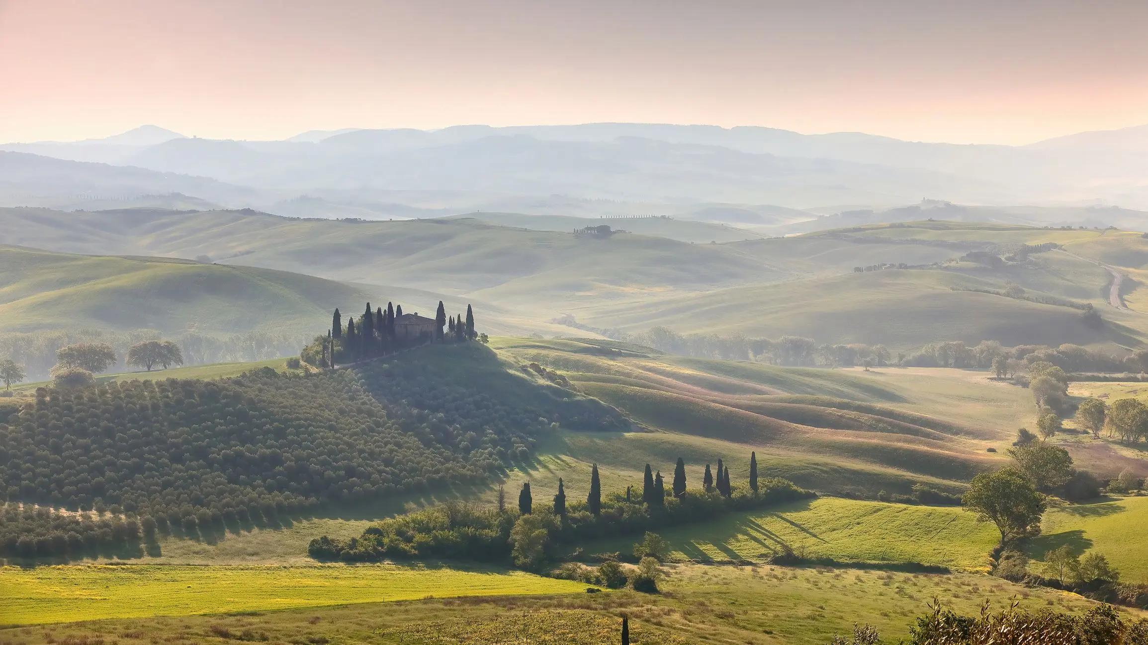 A misty sunrise over Val d'Orcia and its rolling hills. 