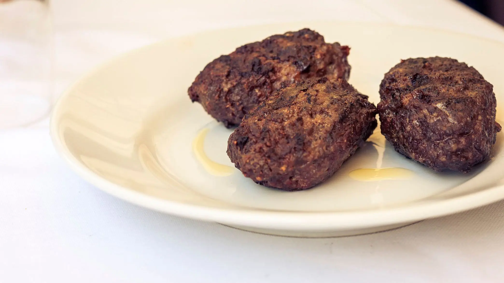 Fried meatballs of horse meat on a white plate in a restaurant in Catania.