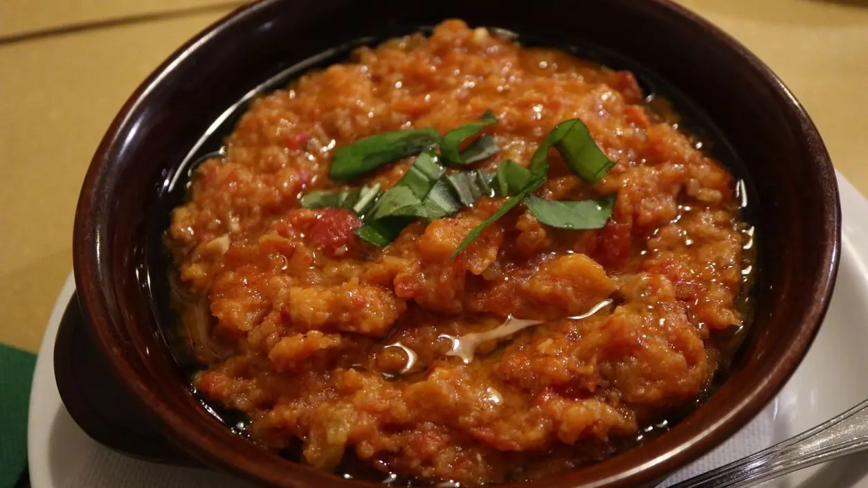 A close-up of a bread and tomato soup.