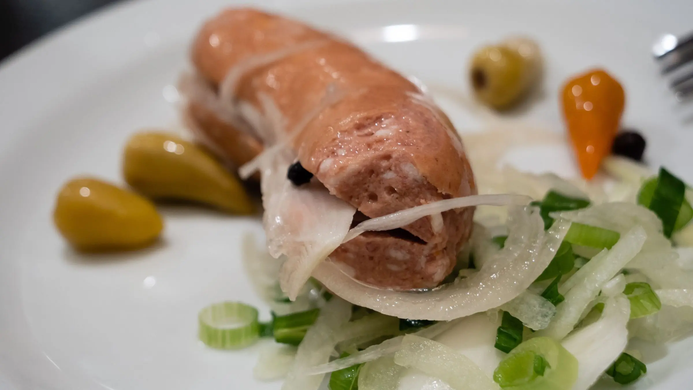 A sausage cut into two and filled with onions.