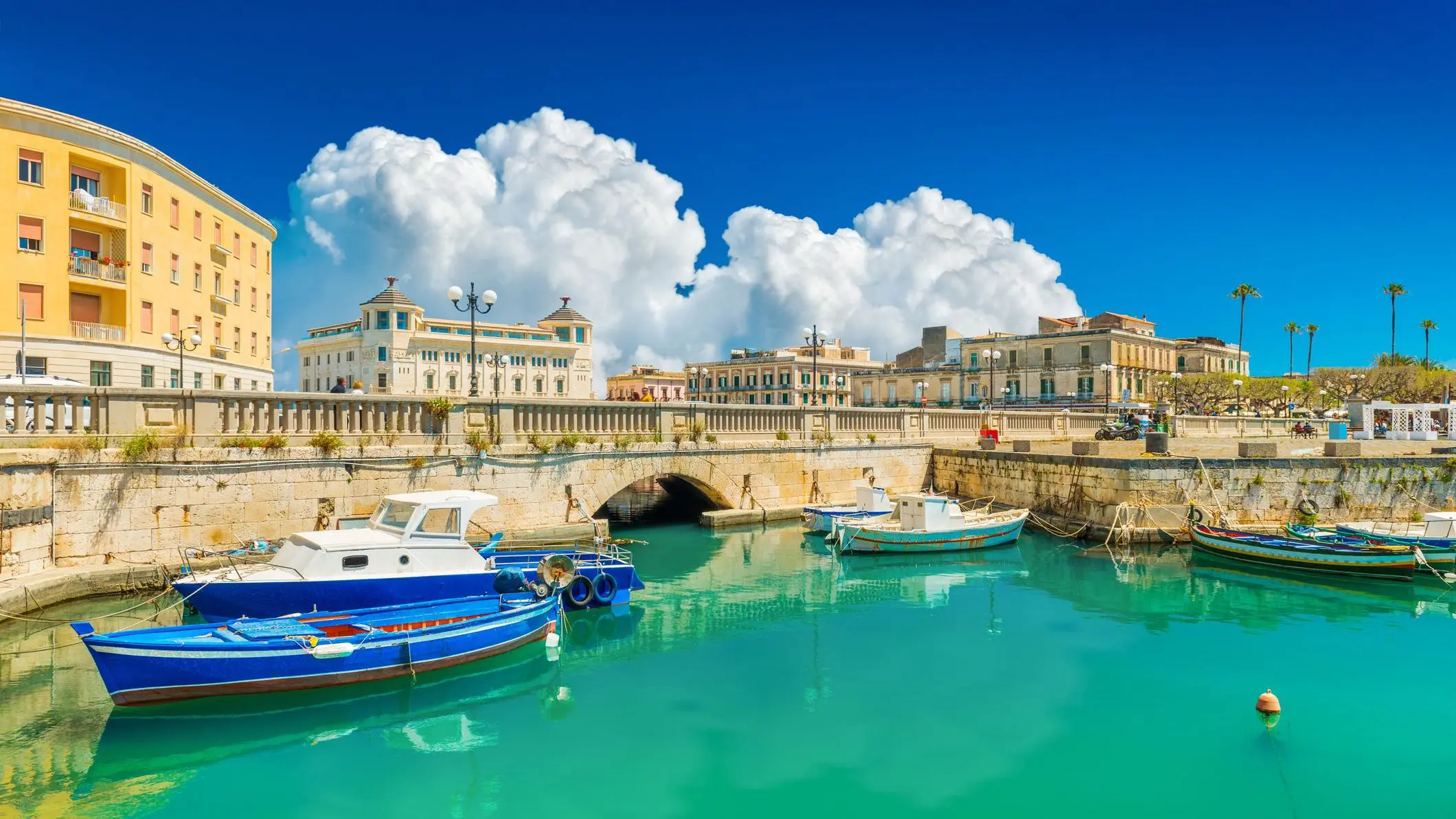 A historic town by the sea with a nice blue sky in the background and traditional boats in the foreground.
