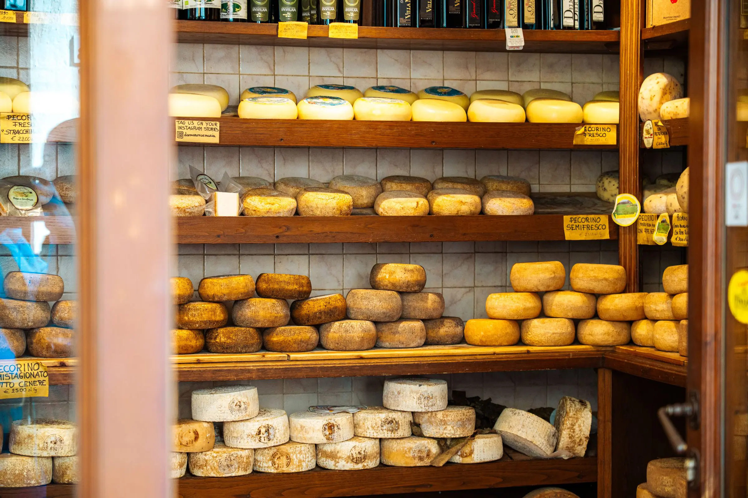 Wooden shelves with wheels of Pecorino cheese, an essential item of the best food in Tuscany.