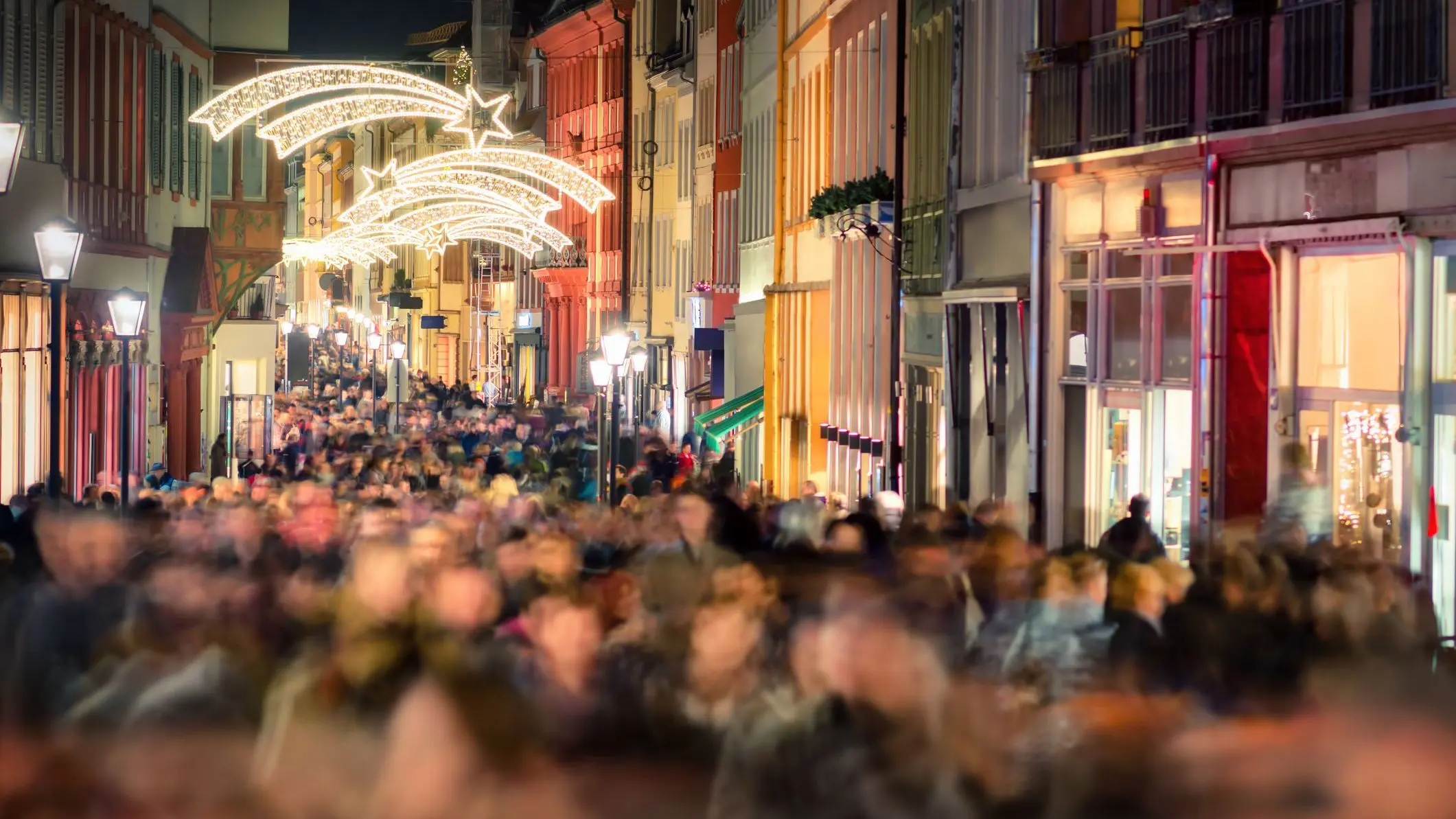 Large crowds of people walking and Christmas shopping in a pedestrian area in Heidelberg, Germany.