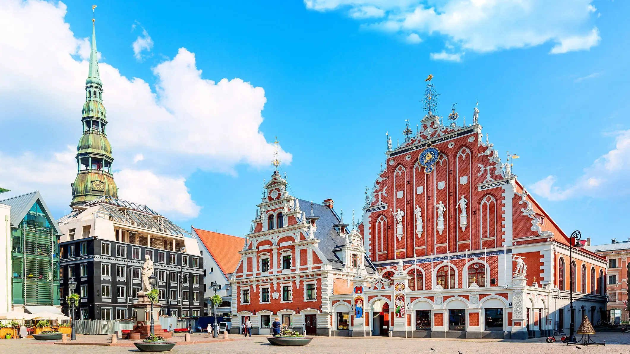 The Blackheads House near St Peters Cathedral against a blue summer sky in Riga, one of the best places to add to your list of where to travel in Europe in 2026. 