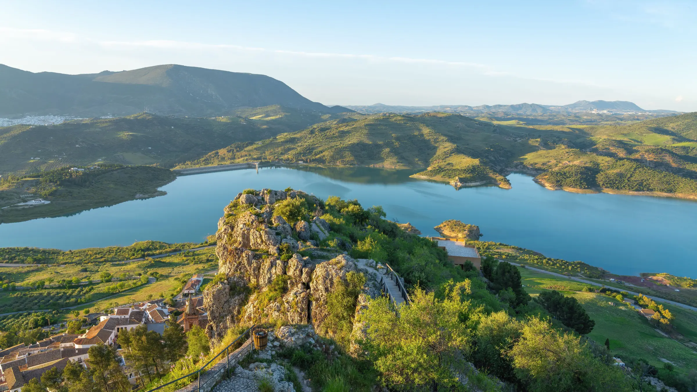 A panoramic view of a lake and green hills. 