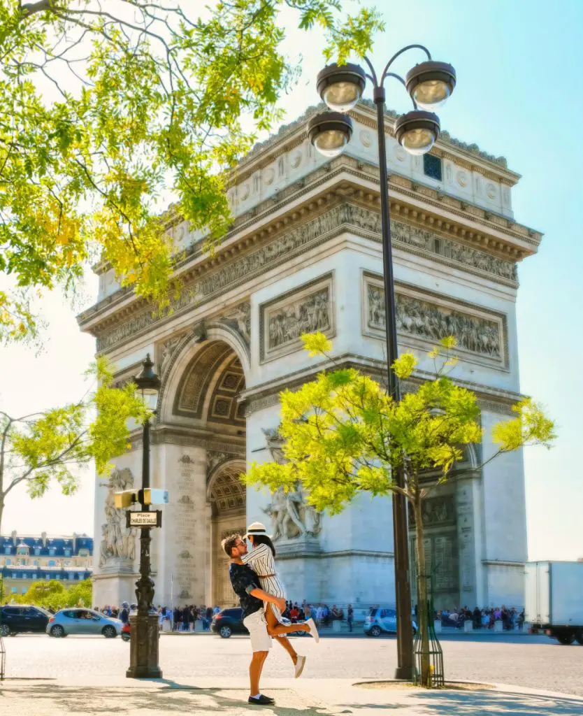 Couple on a citytrip in Paris visiting Avenue des Champs Elysees Paris France Arc De Triomphe. Men and women visiting the Arc de Triomphe in Paris